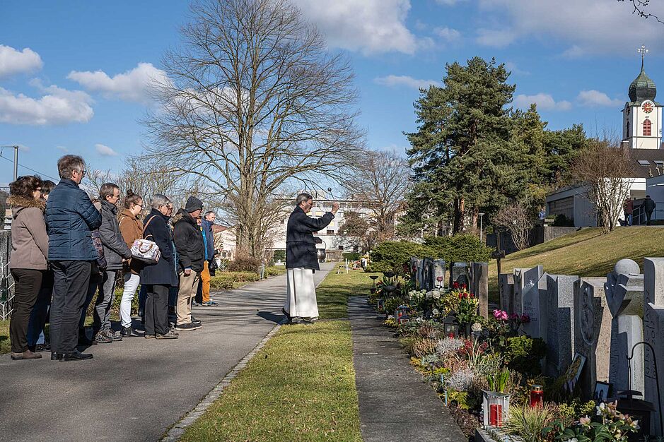 Seelsorger auf dem Friedhof Ebikon, der ein Grab segnet